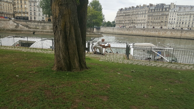 Pintor contemplando o rio Sena